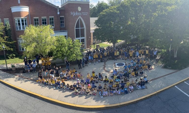 Aerial view of the whole school community gathered outside the building